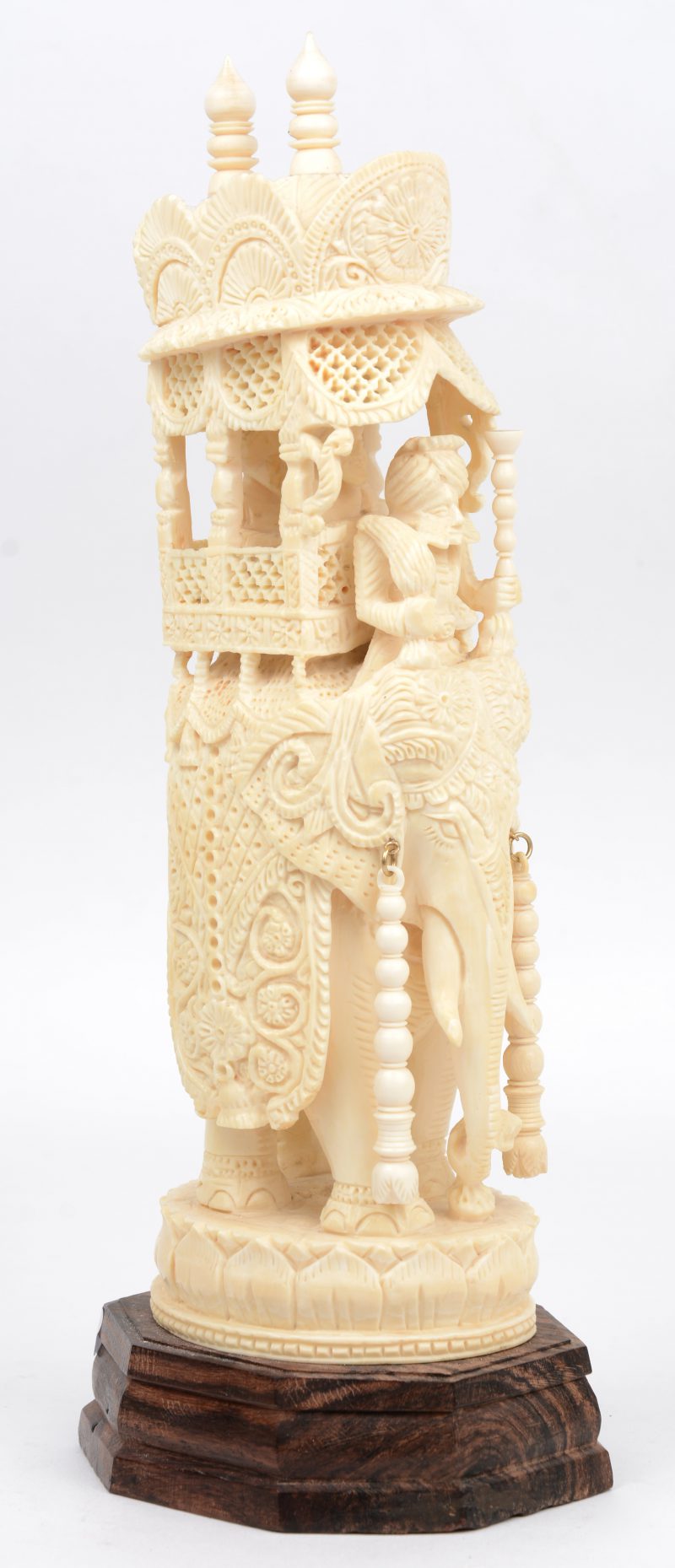 Een rijkelijk uitgewerkte olifant met personages in een opengewerkt rijtuig. Indisch werk. Op houten sokkel.