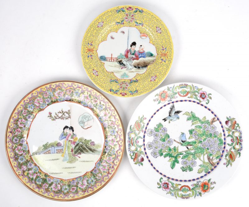 Een lot van drie verschillende borden van Chinees porselein met meerkleurige decors. XXe eeuw, allen gemerkt onderaan.