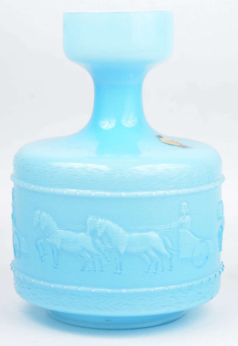 Een vaas van blauw opaalglas met een reliëfdecor van paardenspannen in een fries. Italiaans werk.