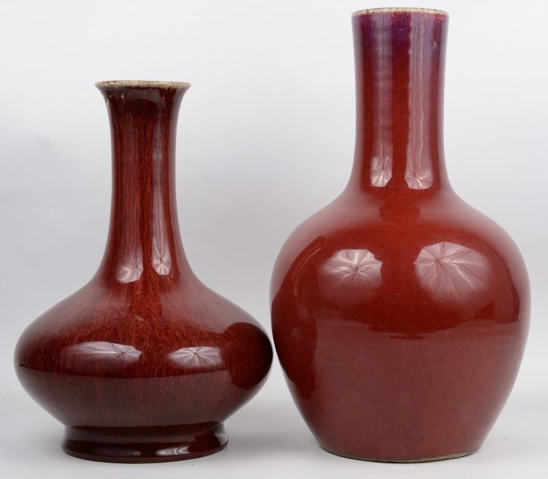 Twee verschillende vazen van Chinees aardewerk met een sang-de-boeufglazuur. De kleinste met restauratie aan de rand.
