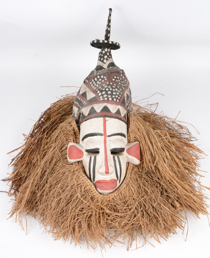 Een gepolychromeerd Afrikaans masker van hout, stro en stof.