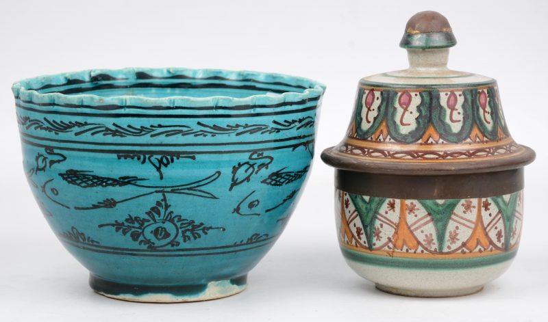 Een Perzisch aardewerken dekselpotje met koperen rand en een aardewerken kom met blauw glazuur.