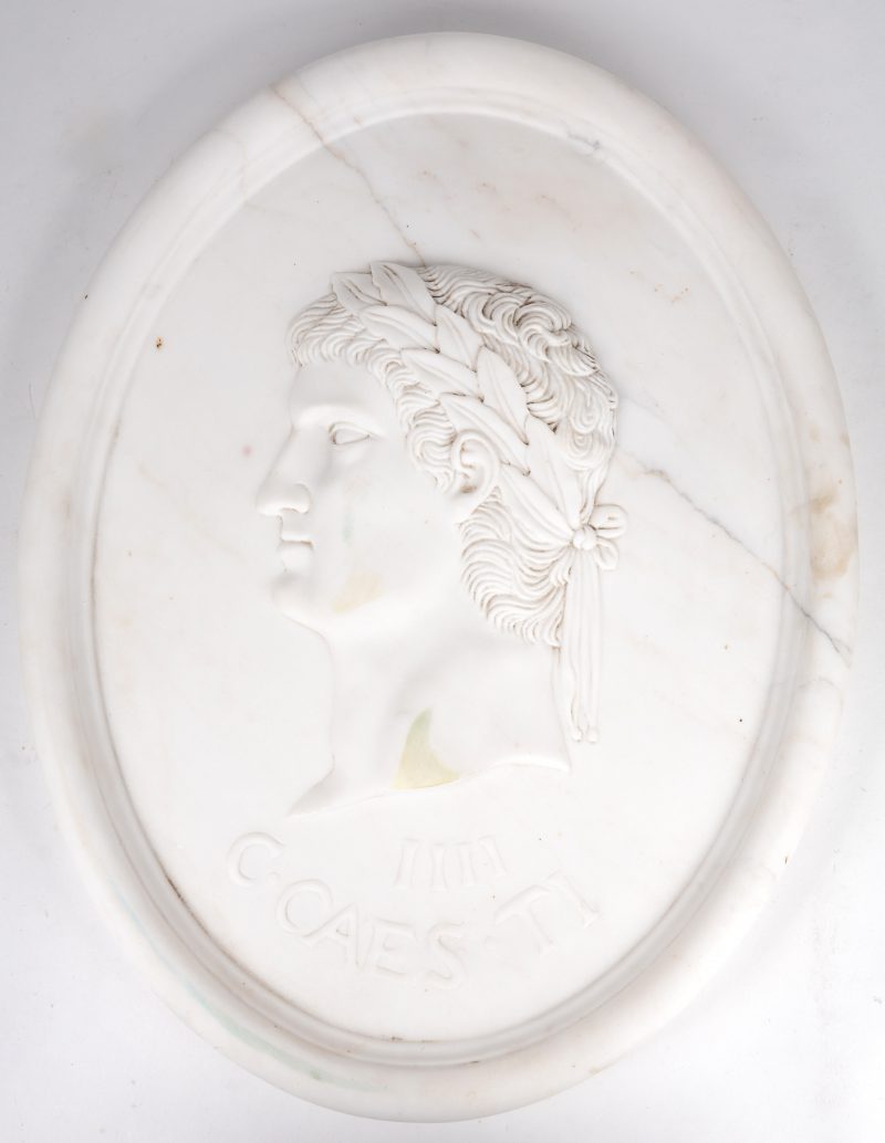 Een kunststof plaquette in marmerlook met beeltenis van een Romeins keizer.