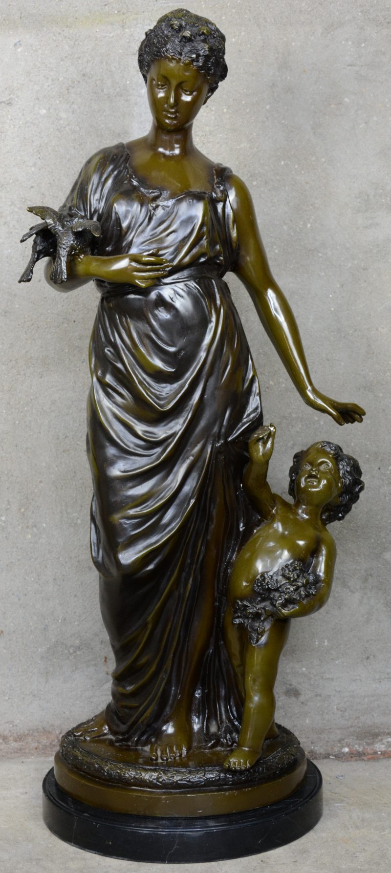 “Jonge vrouw met putto en twee duiven”. Bronzen beeld met bruin patina op marmeren voetstuk. Postume geut.