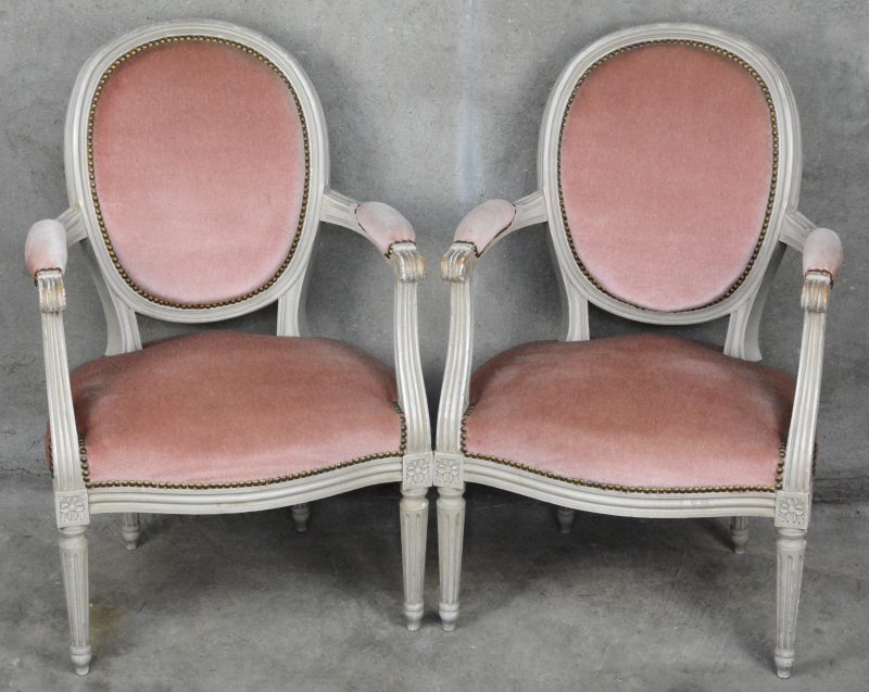 Een paar grijsgepatineerde fauteuils in Lodewijk XVI-stijl, bekleed met roze fluweel.