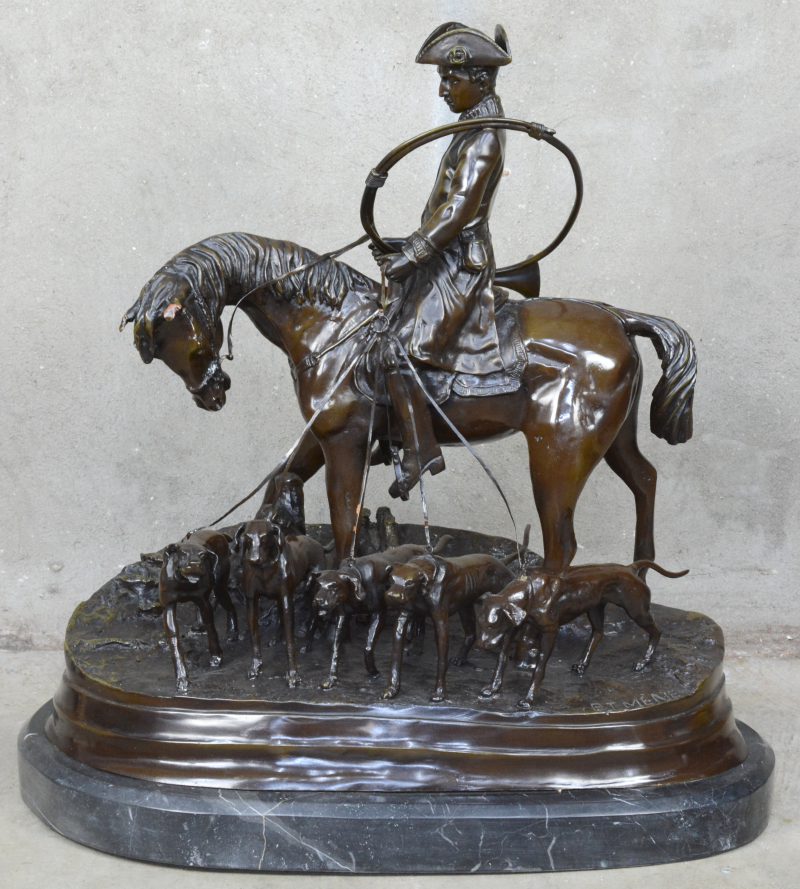 “Jager te paard met jachthoorn en -honden”. Een grote bronzen groep op marmeren voetstuk. Recente geut naar werk van P. J. Mêne.