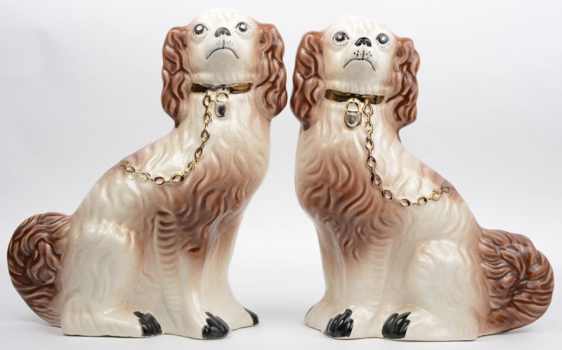 Een paar honden van meerkleurig Staffordshire-aardewerk.