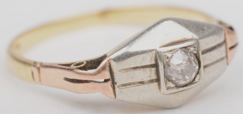 Een 18 karaats wit- en geelgouden ring, bezet met een diamant oude slijp van +/- 10 punten. Tijdperk art deco.
