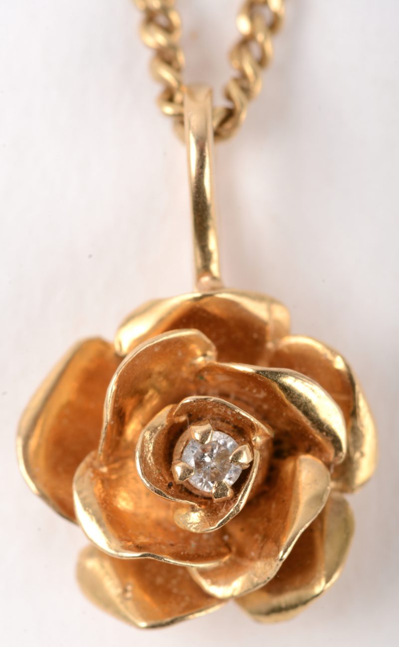 Een 18 K geelgouden ketting met hanger in de vorm van een roos bezet met één diamantje.