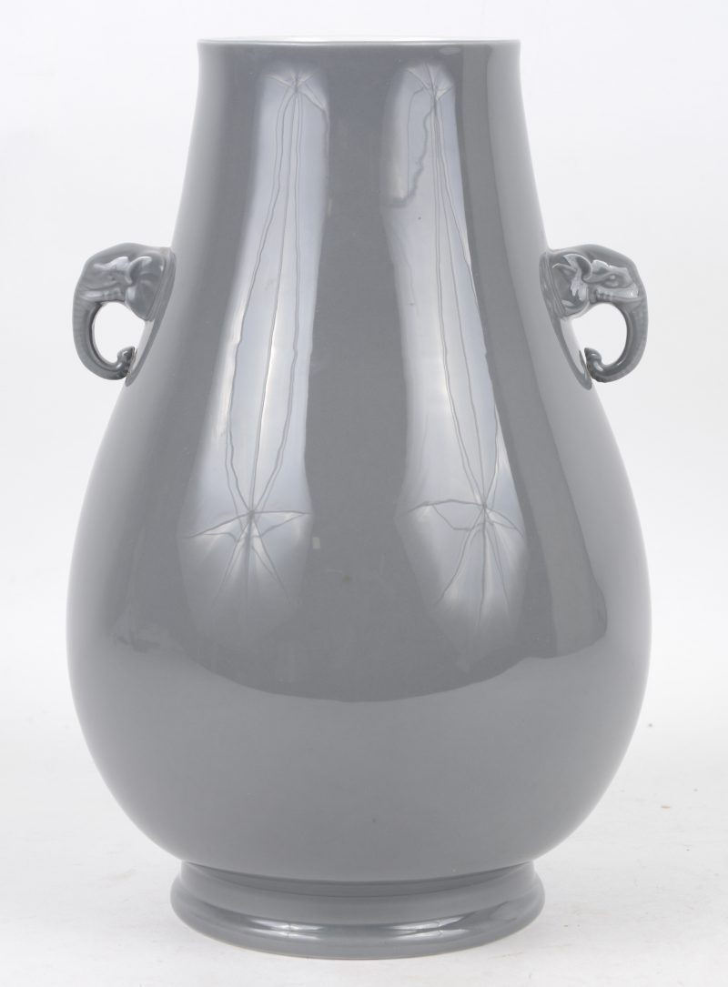 Een vaas van grijs opaalglas, versierd met olifantjes.