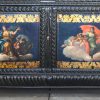 Een vitrinekast van gebeeldhouwd en zwartgepatineerd hout  op eeuwenpoten. Onderaan twee gebombeerde paneeldeuren, versierd met handgeschilderde allegorische decors, omzoomd met acanthuisbladeren. Tijdperk Napoleon III.
