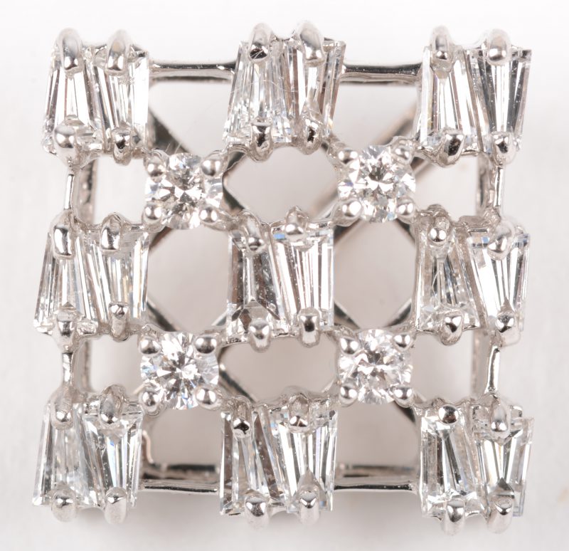 Een 18 K witgouden hanger bezet met vier briljanten en diamantbaguetten met een gezamenljk gewicht van +- 0,80 ct.