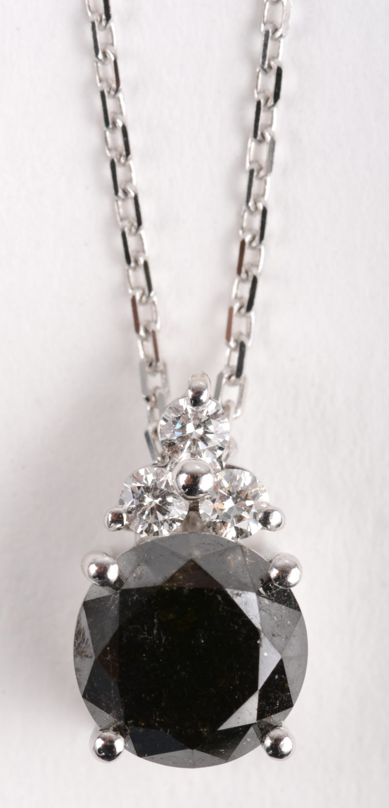 Een 18 K witgouden ketting met hanger bezet met briljanten met een gezamenlijk gewicht van +- 0,12 ct. en een zwarte diamant van +- 2,12 ct.