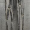 Twee langgerekte Afrikaanse houten voorouderbeelden. Op houten voet.