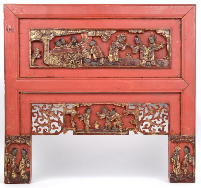 Een roodgelakt Chinees houten meubelpaneeltje met uitgestoken en vergulde personages.