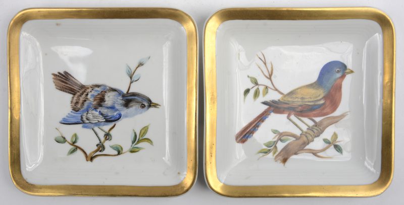 Twee vierkante broodbordjes van meerkleurig Limogesporselein met handgeschilderde decors van vogels en met vergulde rand. Onderaan gemerkt.