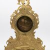 Een verguld bronzen schouwpendule in Lodewijk XV-stijl. email wijzerplaat gebarsten. Sleutel, slinger, bel en dekplaat achteraan manco.