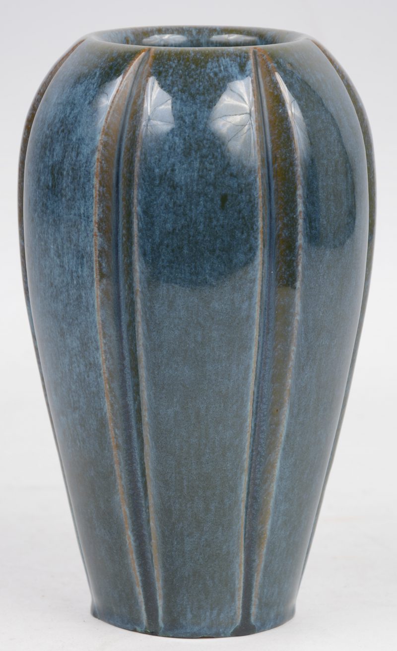 Een aardewerken vaasje met blauw glazuur.