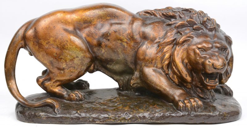 Een leeuw van plaaster met goudkleurig patina.