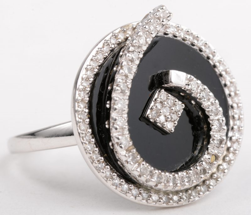 Een 18 K witgouden ring bezet met briljanten met een gezamenlijk gewicht van 0,40 ct. en onyx.
