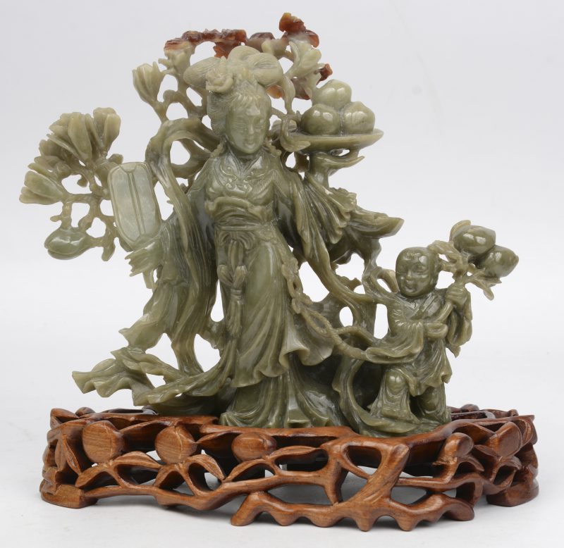 Een gesculpteerde groep van Chinees jade. Op gesculpteerde houten sokkel.