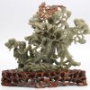 Een gesculpteerde groep van Chinees jade. Op gesculpteerde houten sokkel.