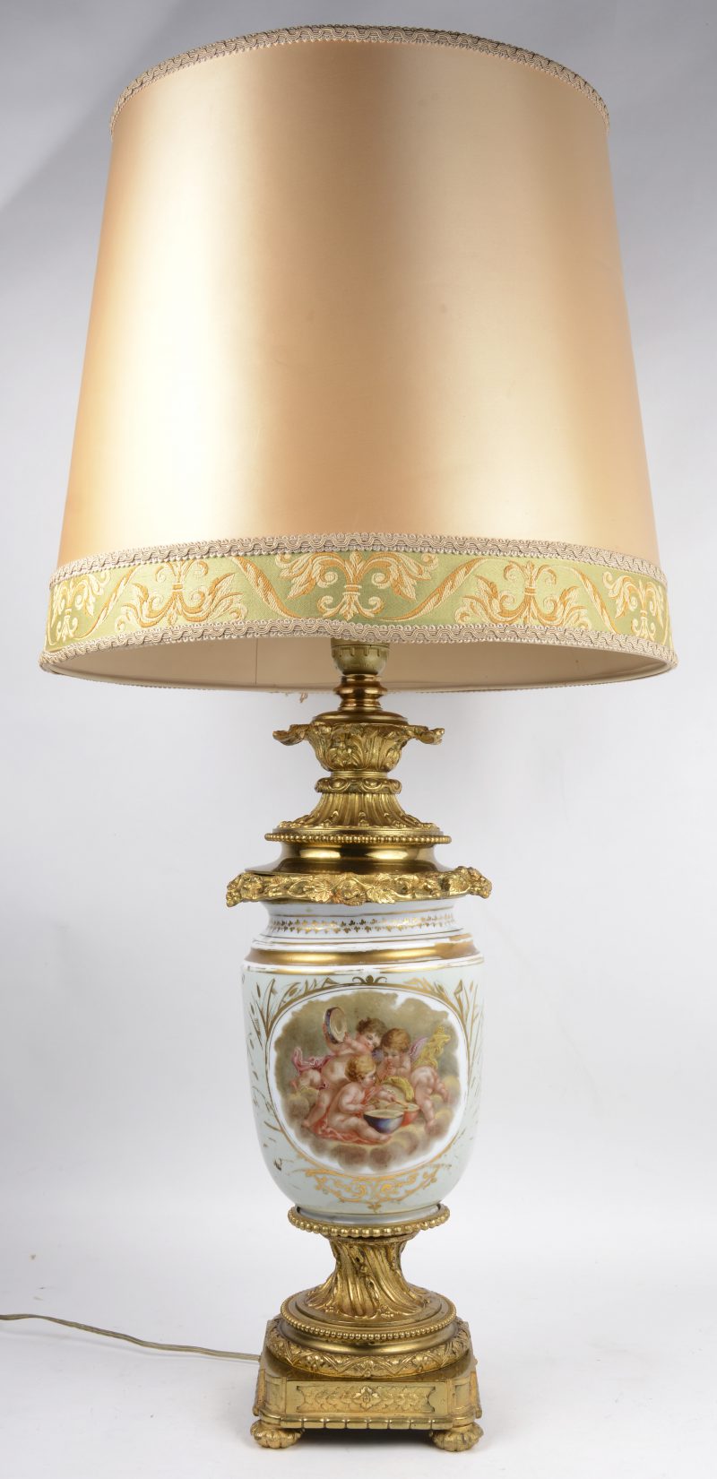 Een schemerlamp met lampenvoet van meerkleurig porselein en verguld brons, versierd met bloemendecor.