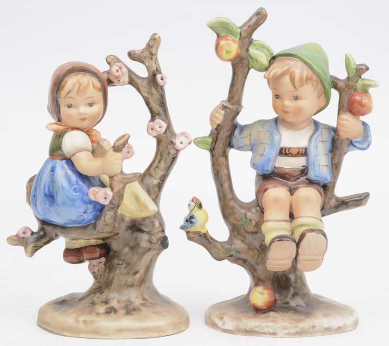 “Apple tree boy” & ”Apple tree girl”. Twee beeldjes van meerkleurig biscuit uit de reeks van M.I. Hummel. No.141 & 142/1. Onderaan gemerkt.