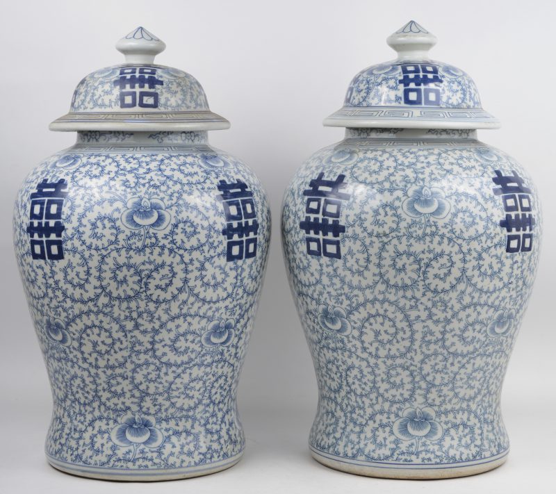 Een paar dekselvazen van Chinees porselein met een blauw op wit decor met langlevenstekens op florale achtergrond.