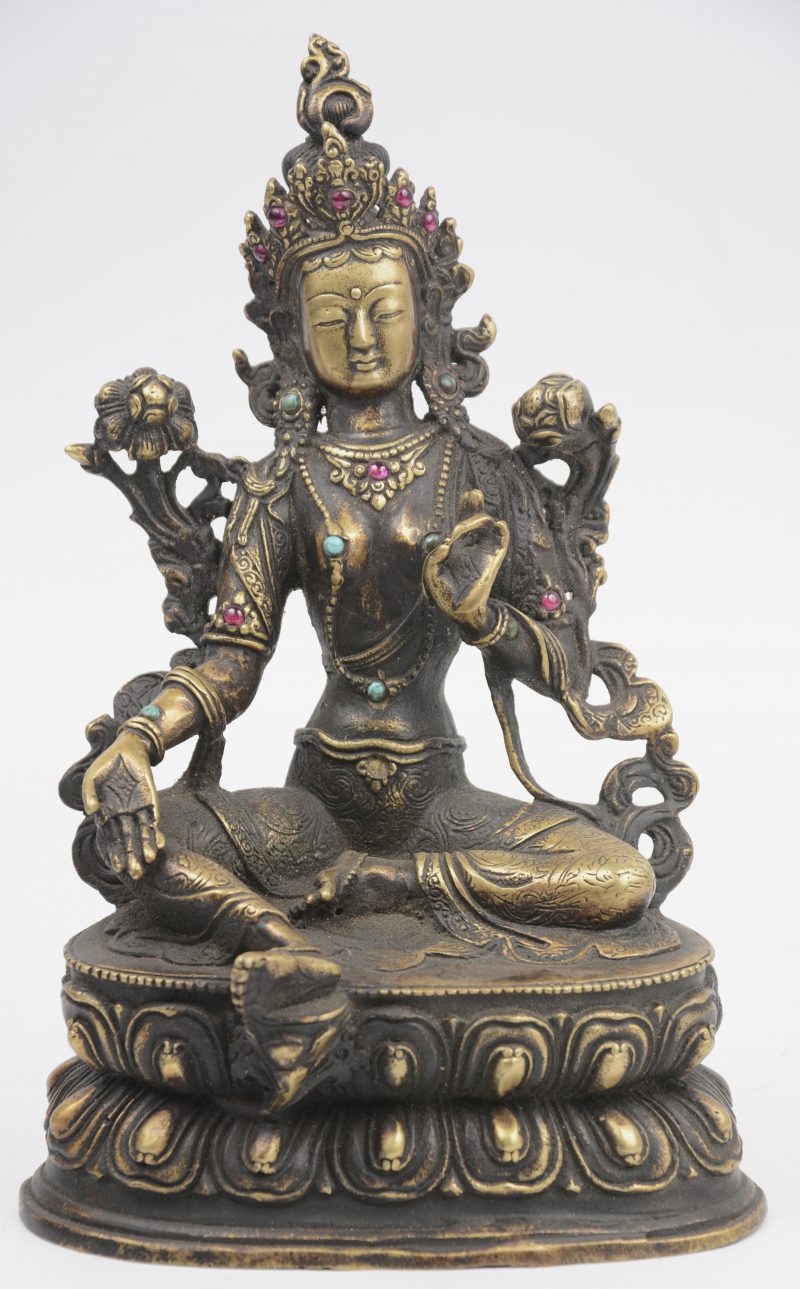 Een bronzen Boeddha met glazen steentjes.