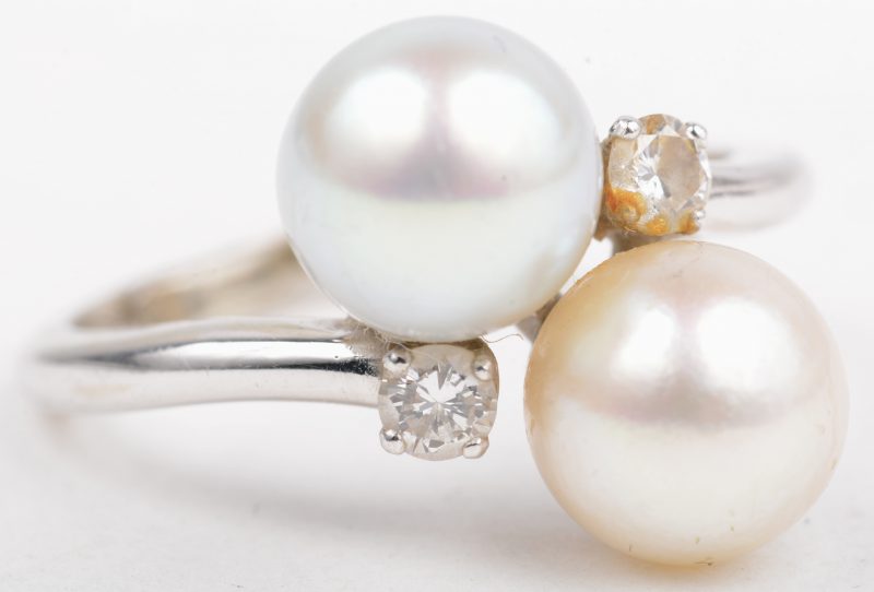 Een 18 K witgouden ring bezet met twee briljanten met een gezamenlijk gewicht van +- 0,10 ct. en een grijze en een beige parel.