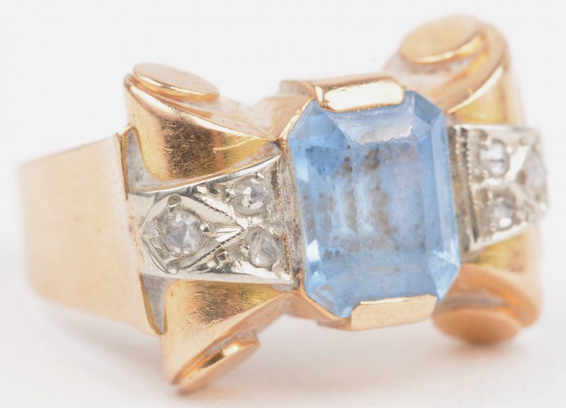 Een 18 K geelgouden ring bezet met twee briljanten met een gezamenlijk gewicht van +- 0,10 ct. en een licht blauwe steen.