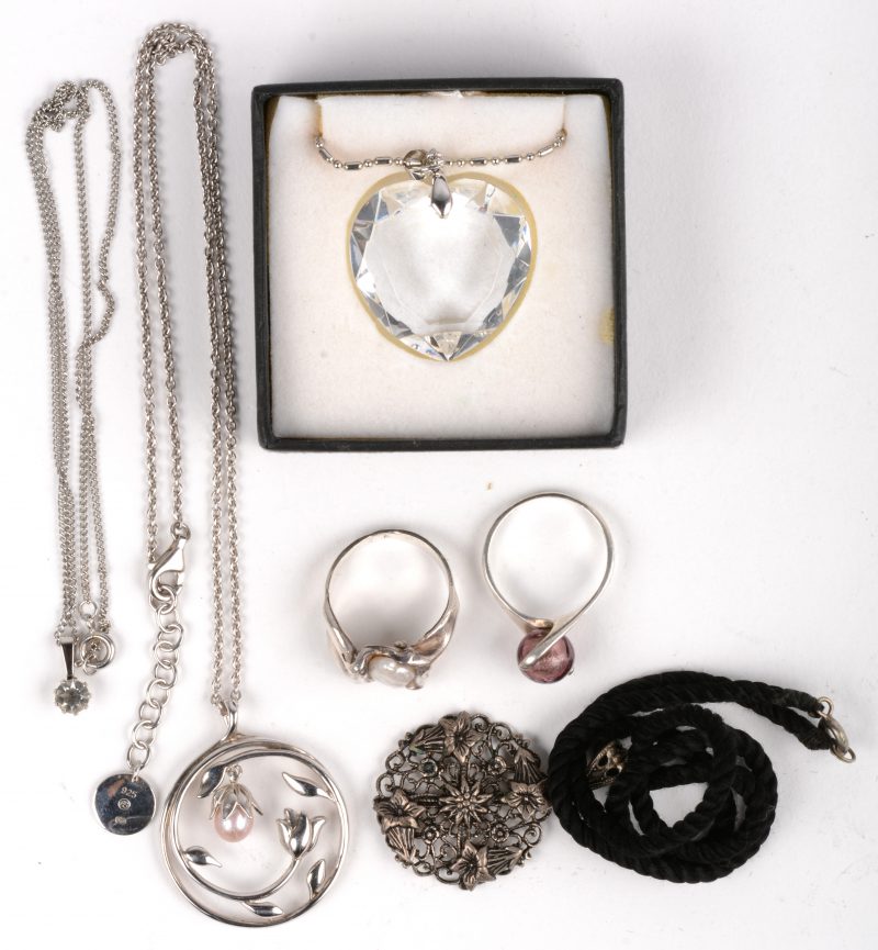 Een lot zilveren juwelen waaronder twee ringen en kettingen met hangers bezet met parels en kristal.