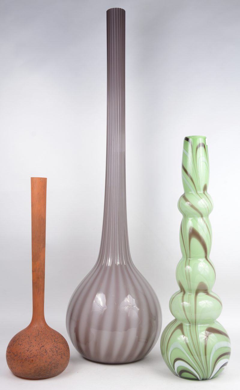 Drie verschillende decoratieve designvazen van gekleurd glas.