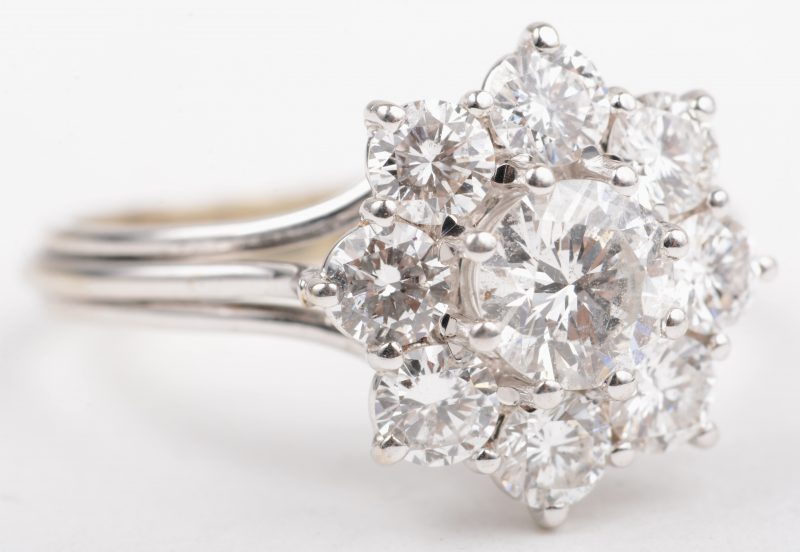 Een 18 K witgouden bloemvormige ring bezet met briljanten met een gezamenlijk gewicht van +- 1,30 ct.