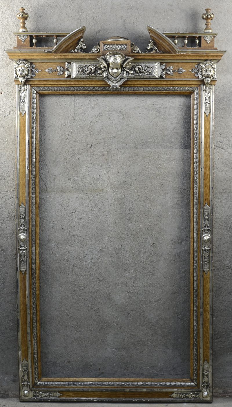 Een spiegellijst in empirestijl met verzilverd bronzen versieringen.