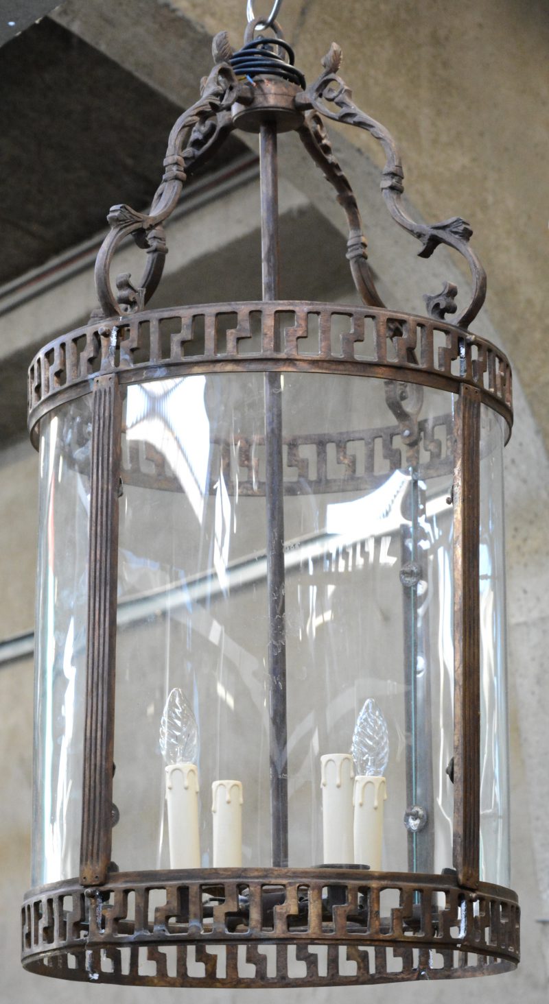 Een ronde bronzen hanglantaarn met bol glas.