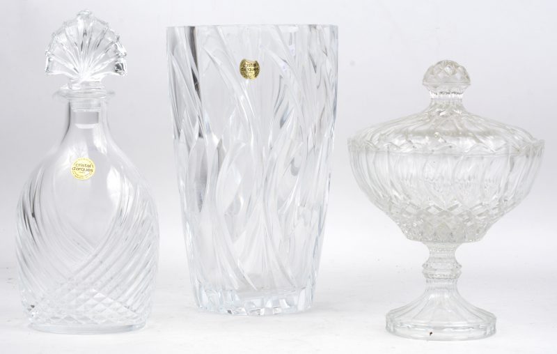 Een vaas en een karaf van geslepen kleurloos kristal. Gemerkt van Cristal d’Arques. We voegen er een kleurloos glazen bonbonnière op voet aan toe.