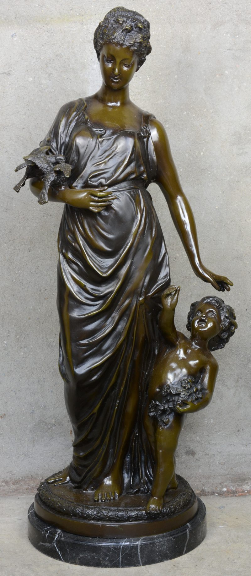 “Jonge vrouw met putto en twee duiven”. Bronzen beeld met bruin patina op marmeren voetstuk. Postume geut.