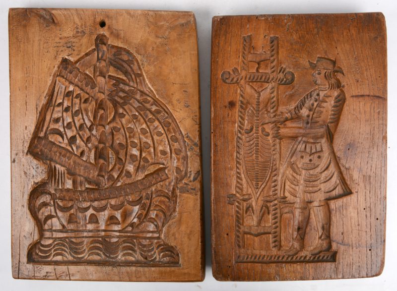Twee antieke houten speculaasplanken, waarbij een dubbele met vorm van een hond en een personage en de andere met vorm van een zeilschip. Holland, XVIIIe eeuw.
