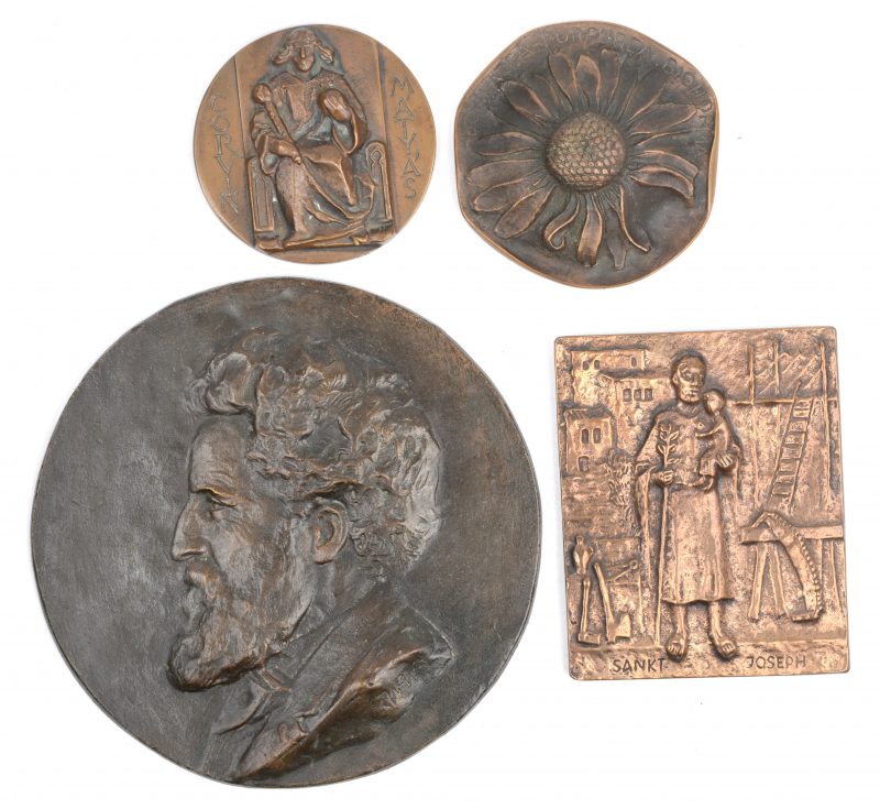 Een lot van vier reliëfjes van brons of koper, waarbij één met afbeelding van Sint Jozef, één met afbeelding van Mathias Corvinus van Hongarije, een asbakje met een bloem en een reliëf met een herenprofiel