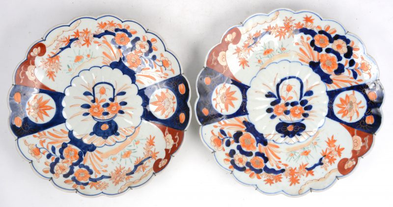 Een paar borden van Imariporselein met meerkleurige bloemendecors en gelobde randen. XIXe eeuw.