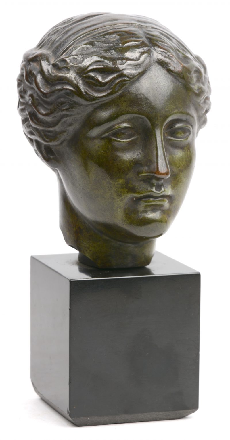 “Aphrodite van Melos”. Een bronzen hoofd op zwart stenen sokkel.