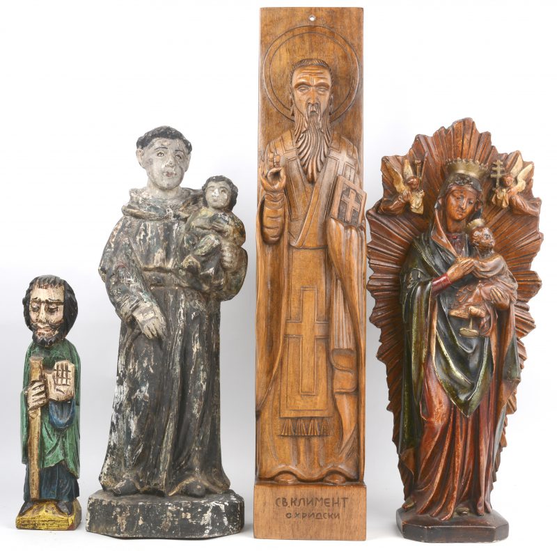 Een lot van vier houten heiligenbeelden, waarbij drie gepolychromeerd.
