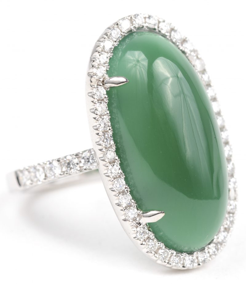 Een 18 K witgouden ring bezet met briljanten met een gezamenlijk gewicht van +- 0,53 ct. en cabochon van jade van +- 8,04 ct.