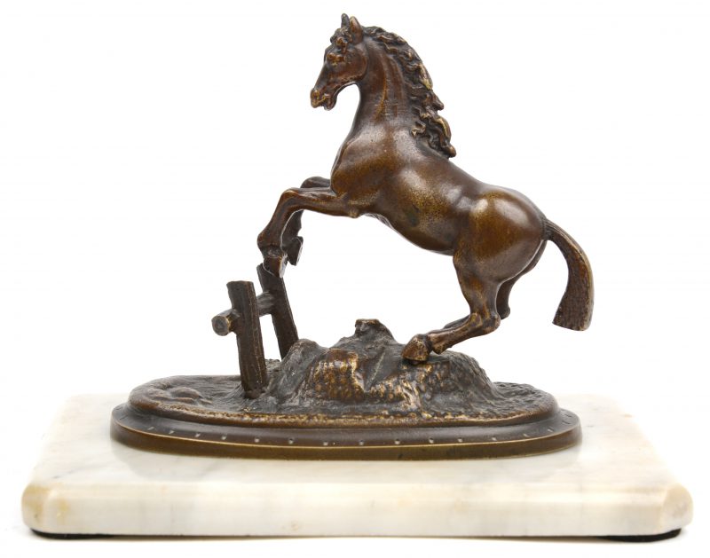 Een stijgerend paardje van brons op losse marmeren sokkel.