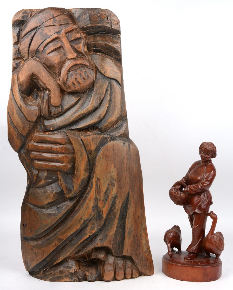 “Vrouw met ganzen”. Een beeldje van gesculpteerd hout. Chinees werk. Bijgevoegd een gestoken houten wandversiering.