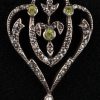 Een 18 K witgouden ketting en hanger van wit goud op zilver uit de Belle Epoque, bezet met kleine diamantjes met een gezamenlijk gewicht van +- 0,40 ct. peridot en parels.