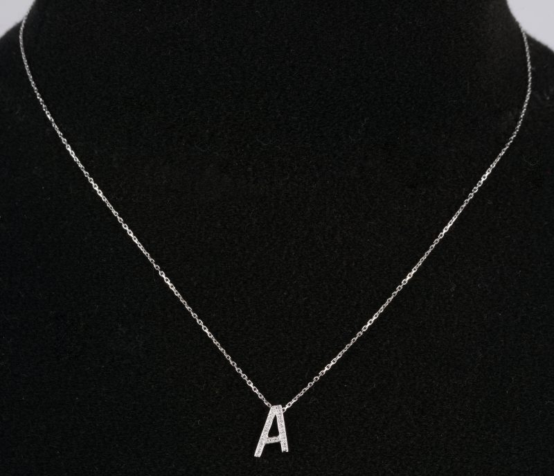 Een 18 K witgouden ketting met hanger met de letter “A” bezet met briljanten met een gezamenlijk gewicht van +-0,10 ct.