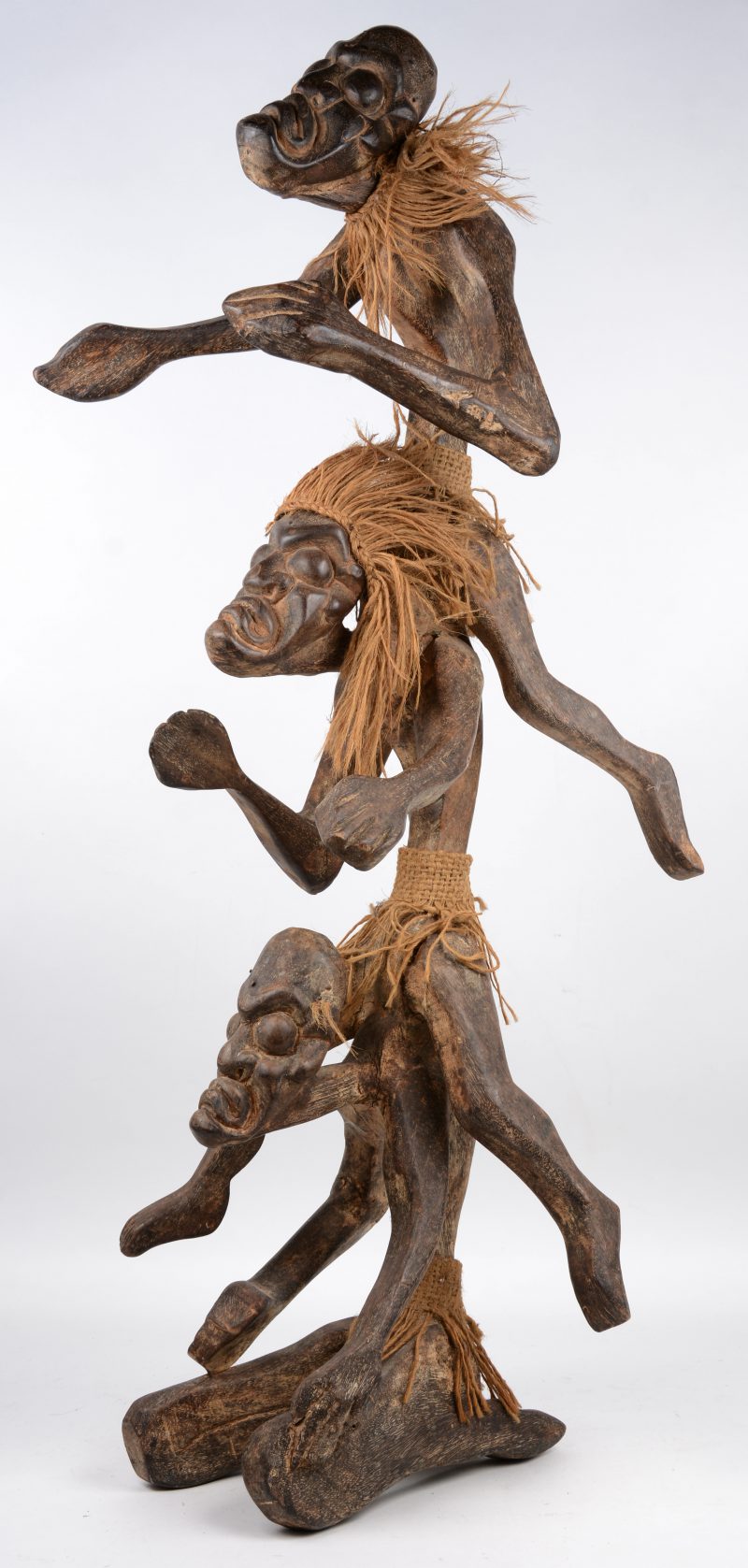 Een Afrikaans houten beeld in de vorm van drie figuren.